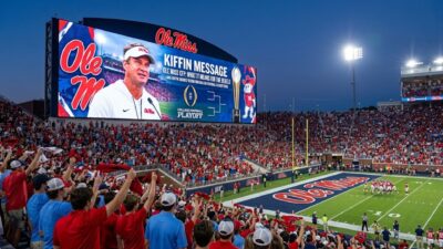 Lane Kiffin graphic on Ole Miss stadium jumbotron showing College Football Playoff message to cheering fans